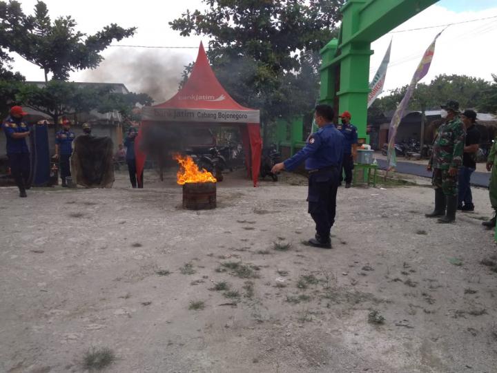 Anggota Satgas TMMD Bojonegoro Membantu Mempraktekkan Pelaksanaan Cara Penanganan Bahaya Kebakaran